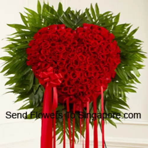 Un magnifique arrangement en forme de cœur de 100 roses rouges