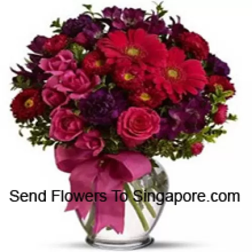 Roses roses, Géraniums rouges et autres fleurs assorties disposées magnifiquement dans un vase en verre - 36 tiges et remplissages